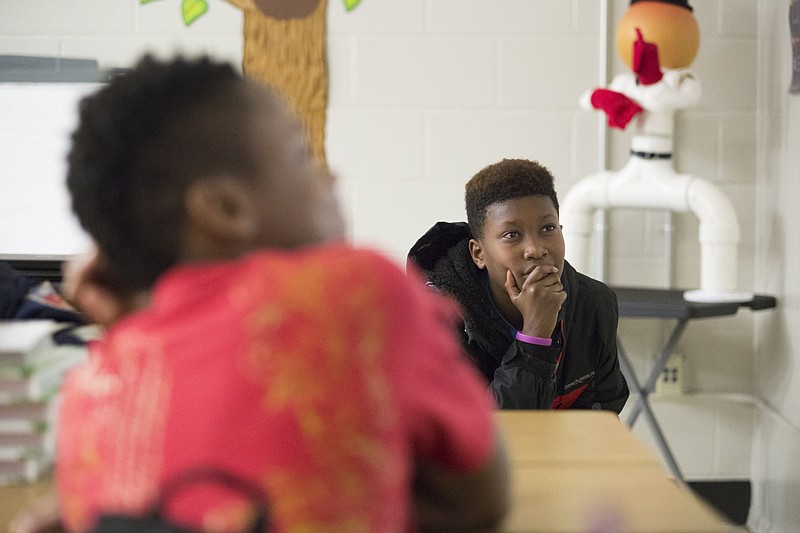 Tamarius Golston watches the inauguration Friday of the forty-fifth president of the United States, Donald Trump, in Rhonda Adams' sixth-grade Social Studies class at College Hill Middle School. Students listened and asked questions about the content of his speech. 