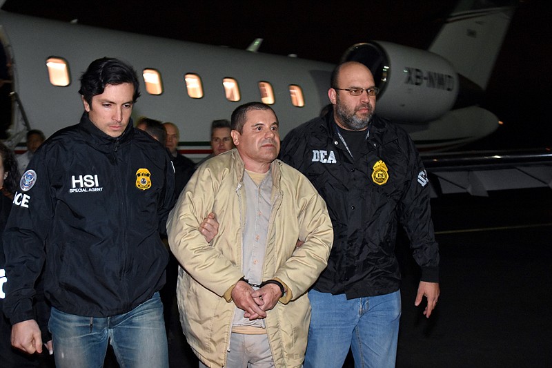 Authorities escort Joaquin "El Chapo" Guzman, center, from a plane to a waiting caravan of SUVs Thursday at Long Island MacArthur Airport in Ronkonkoma, N.Y.