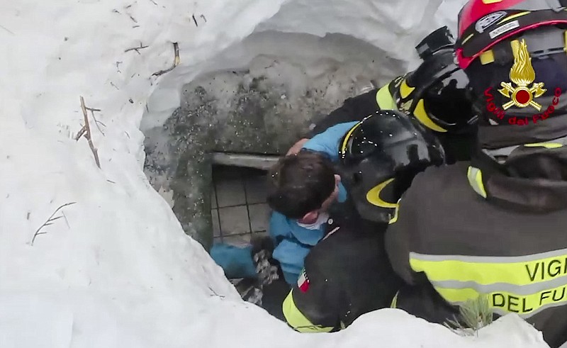 This frame from video shows Italian firefighters extracting a boy alive Friday from under snow and debris of a hotel that was hit by an avalanche on Wednesday in Rigopiano, central Italy.