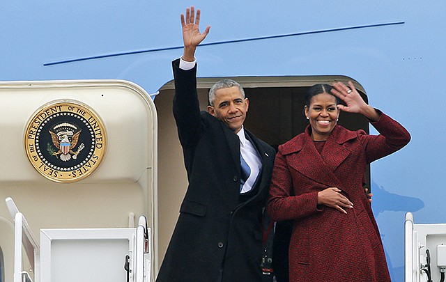 Former President Barack Obama and his wife Michelle wave Friday to the crowd as they board an Air Force jet to depart Andrews Air Force base in Andrews Air Force Base, Maryland.