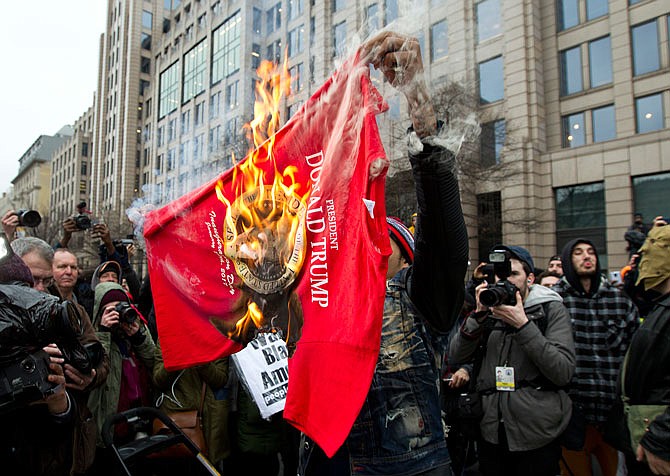 Demonstrators burns a Trump t-shirt during a demonstration Friday in downtown Washington during the inauguration of President Donald Trump. 