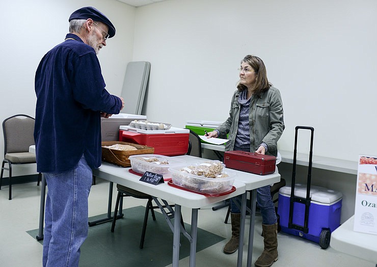 Pam Schmutzler helps a customer at her vending area. Schmutzler sells a variety of goods, from eggs and vegetables to desserts and nuts. Schmutzler and other attending vendors benefit from Lincoln University's Winter Farmers Market as it helps keep their customer base and allows them to continue selling their produce in between the outside farmers market seasons.
