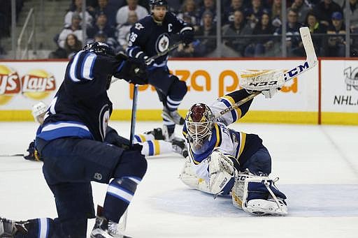 St. Louis Blues goaltender Pheonix Copley (30) saves a shot from Winnipeg Jets' Mathieu Perreault (85) as Jets' Blake Wheeler (26) looks on during the second period of an NHL hockey game in Winnipeg, Manitoba, Saturday, Jan. 21, 2017. (John Woods/The Canadian Press via AP)