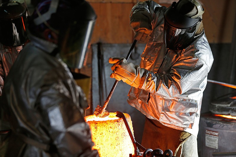 In this Dec. 20, 2016 photo, workers prepare to work on Garland's 15-foot bronze sculpture designed by artist Barvo Walker at Schaefer Art Bronze Casting in Arlington Texas. The $300,000 Vision of the Arts sculpture will be finished in early 2017 and stand before Granville Arts Center in Garland, Texas. 