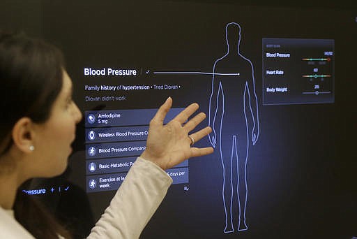 In this Jan. 10, 2017 photo, Dr. Aaliya Yaqub points to a large monitor while giving a demonstration of medical checkup at a Forward medical office in San Francisco. 