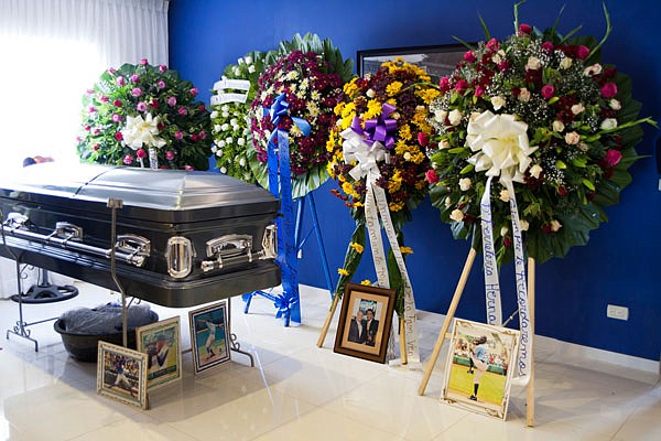 The coffin containing the remains of Royals pitcher Yordano Ventura is surrounded by funeral wreaths and images of the major league player Monday in the living room of one his two homes in Las Terrenas, Dominican Republic.