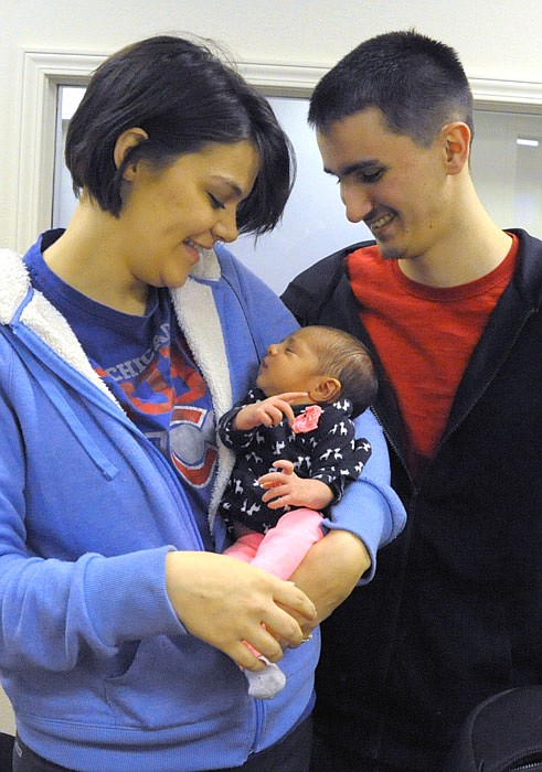 Lee Ann and Daniel Palmer look at their daughter Leona Rae, who was Moniteau County's First Baby of the Year.