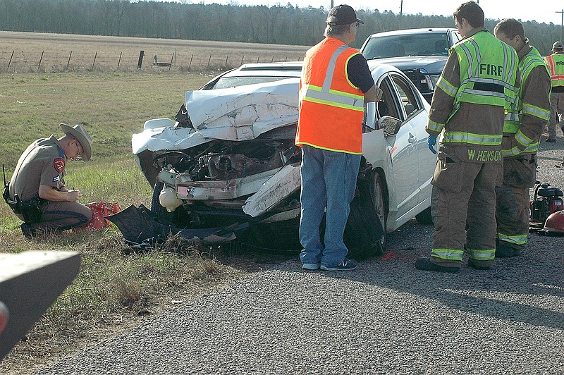 A trooper with the Texas Department of Public Safety writes notes as part of the investigation into a fatal wreck Wednesday on U.S. Highway 71, about 1.5 miles north of Texarkana, Texas. The vehicle was traveling northbound on Highway 71. Area fire departments directed traffic at the accident scene.
