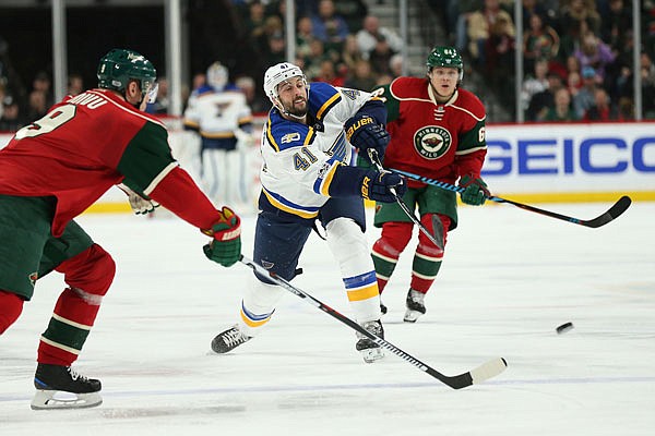 Robert Bortuzzo of the Blues passes the puck against Mikko Koivu of the Wild in the second period of Thursday night's game in St. Paul, Minn.