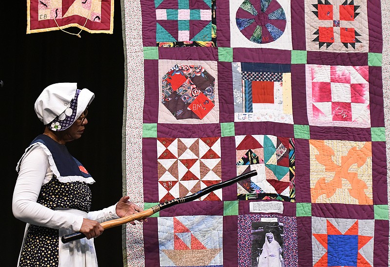 Flo Stevenson of the Pleasant Hill Quilting Ladies points to a specific quilt square during a presentation for Texas Middle School sixth-graders Thursday at the Sullivan Performing Arts Center. The Pleasant Hill Quilting Ladies are a group of quilters that tell the story of the secret codes and songs used on the Underground Railroad. 
