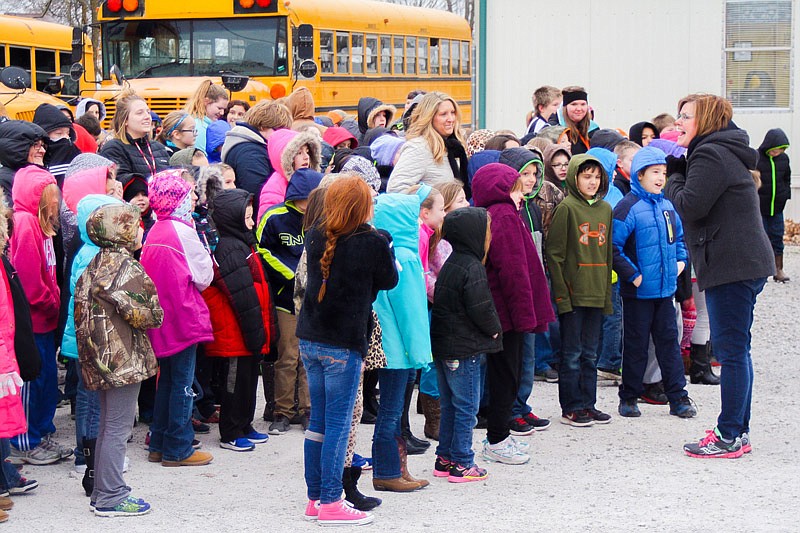 New Bloomfield Elementary Principal Julie Gerloff, right, commends her students after they sang "The Wheels on the Bus." Gerloff said she came up with the idea of saying thanks to the school's bus drivers after January's ice storm.