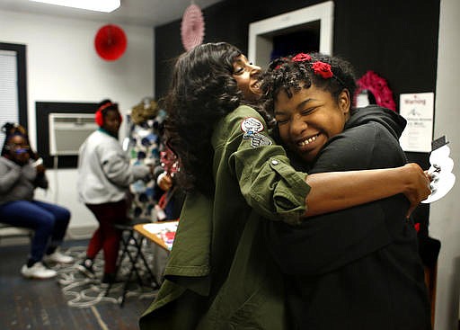 In this Dec. 9, 2016, photo, mentor Crystal Green embraces Amera Porter-Watterson at Workshop Houston in Houston. Porter-Watterson has been attending the after-school program at Workshop Houston for several years and is currently learning how to animate.