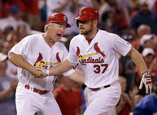 Brandon Moss is congratulated by Cardinals third base coach Chris Maloney while rounding the bases after hitting a two-run home run during a game against the Cubs last September at Busch Stadium.