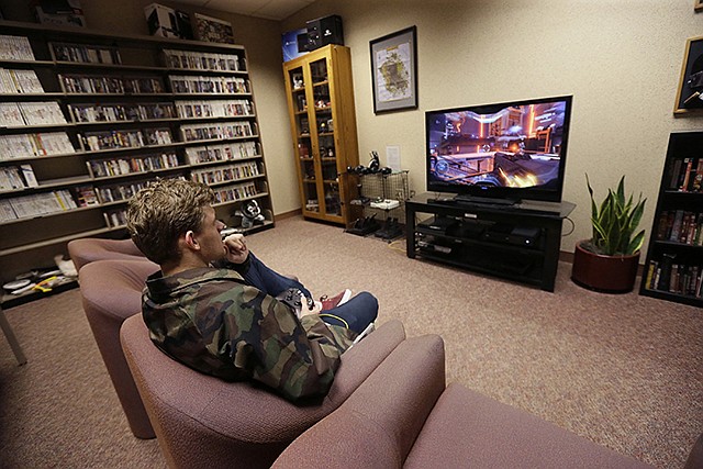 Tyler Aman takes a few minutes of his day to play a video game in May 2016 at the Computer and Video Game Archive at the Duderstadt Center at the University of Michigan in Ann Arbor. The university's archive features more than 7,000 titles — everything from time-honored favorites such as "Pac-Man" and "Frogger" to newer fare, including "Call of Duty" and "Halo" — on dozens of gaming systems. And unlike some other video game archives out there, students and members of the public alike are permitted to visit and play any game available, whether for research or just to relax.