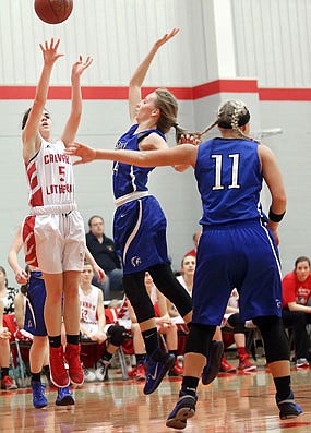 Lily McCarty of Calvary Lutheran shoots against the defense of Chyan Wilkes of Russellville during Thursday night's game at Calvary. McKendra Fischer of Russellville (11) watches on the play.