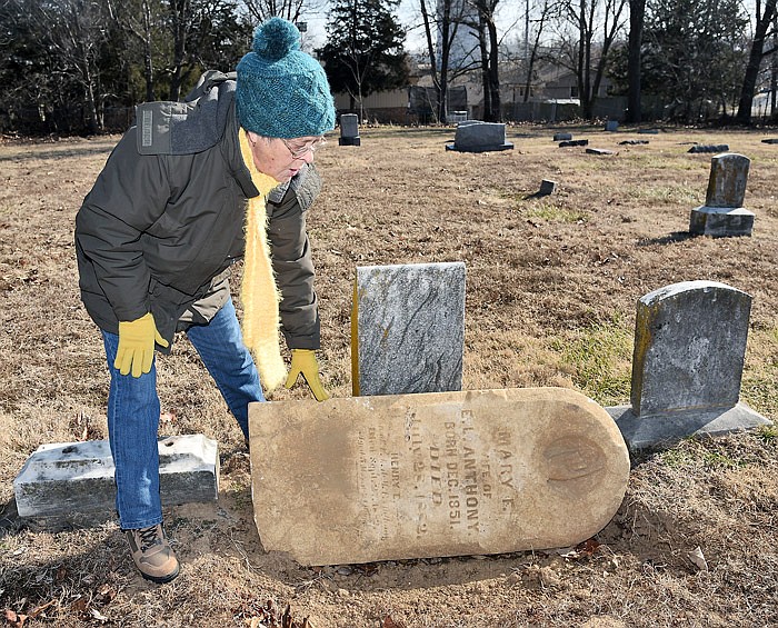In this Feb. 3, 2017 photo, Nancy Thompson shows a broken headstone at Longview Cemetery that she and her sister recently dug up out of the dirt. It goes on the base located directly behind her.
