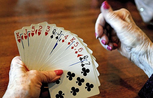 In this April 10, 2014, file photo, a card player studies her hand during a bridge game at a restaurant in St. Paul, Minn. 