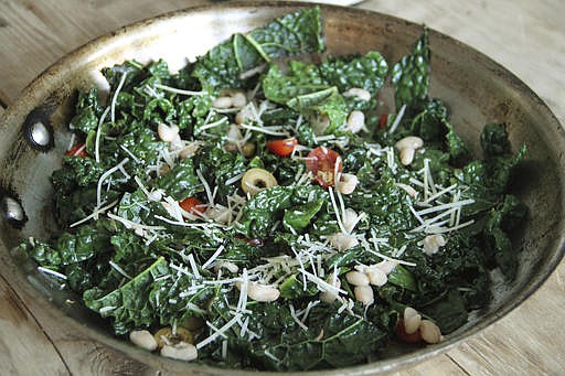 This Jan. 19, 2017 photo shows Tuscan kale sauteed with anchovies, olives, tomatoes and white beans in Coronado, Calif. This dish is from a recipe by Melissa d'Arabian.
