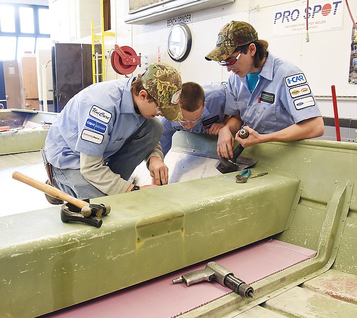 Students in Dennis Bruemmer's Auto Collision class at Nichols Career Center repair a boat during their school day. Fatima student Holden Eichholz drills holes through aluminum while classmates Austin Mueller, also from Fatima, and Austin Buscher, from Blair Oaks, fasten the bolts.