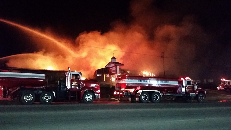 Broken Bow firefighters help others battle a huge blaze Thursday night at Ok Lumber in Idabel, Okla. The fire lasted all night and firefighters were still cleaning up hot spots early Friday morning. No one was injured. The cause of the fire is unknown.
