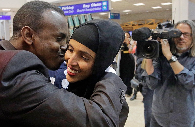 Abdisellam Hassen Ahmed, a Somali refugee who had been stuck in limbo after President Donald Trump temporarily banned refugee entries, kisses his wife Nimo Hashi, after arriving at Salt Lake International Airport, Friday, Feb. 10, 2017, in Salt Lake City. Ahmed meet his 2-year-old daughter, Taslim, for the first time. Ahmed is among a wave of refugees around the country making belated arrivals after their trips were cancelled several weeks ago after Trump's executive order.