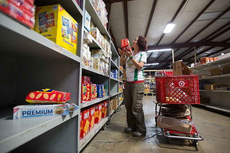 In this February 2017 file photo, Jess Kurti stocks the shelves at the Harvest Texarkana Regional Food Bank. Kurti, from Orlando, Florida, was traveling across the United States to volunteer at all 200 regional food banks in the Feeding America Network.