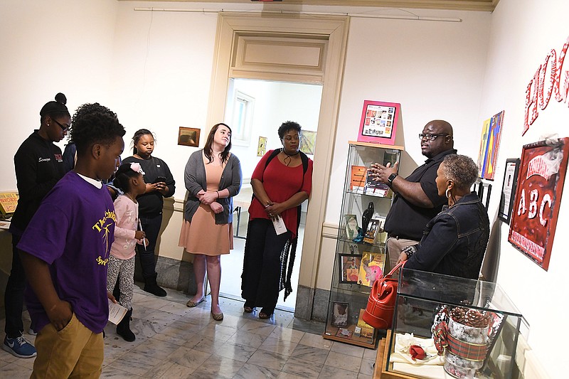 The Rev. Derek Murphy, right, explains the story behind his book "Rewriting Murphy's Law" during the TRAHC African-American Committee's sixth annual Special Afternoon on Saturday at the Regional Arts Center in Texarkana. 