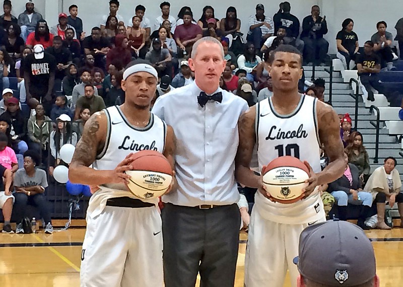 During halftime of the Blue Tigers' game against Lindenwood, Lincoln coach John Moseley presents players Anthony Virdure and Jaylon Smith with basketballs commemorating their 1,000th point. 