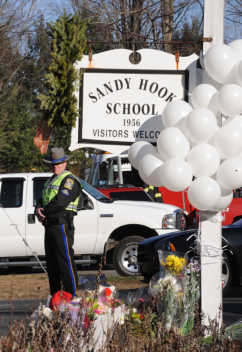 Police officers stand at the entrance to the street leading up to Sandy Hook Elementary School on Saturday, December 15, 2012, in Newtown, Connecticut, a day after a shooting where 26 people died.