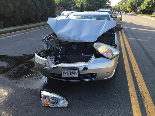 In this photo taken July 14, 2016, a car involved in an accident sits in the road McLean, Va. The Consumer Federation of America says it found premium hikes in some cases reaching $400. It looked at premium quotes in 10 cities from five of the nation's largest auto insurers and found that Progressive aggressively used a not-at-fault penalty, surcharging drivers in eight of the ten cities. 