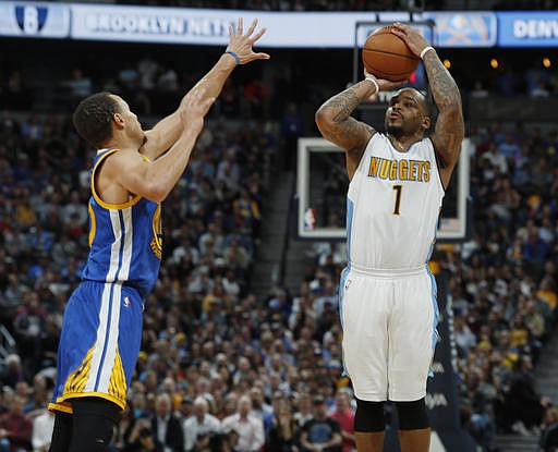 Denver Nuggets guard Jameer Nelson, right, takes a three-point shot over Golden State Warriors guard Stephen Curry in the second half of an NBA basketball game Monday, Feb. 13, 201, in Denver. The Nuggets won 132-110. 