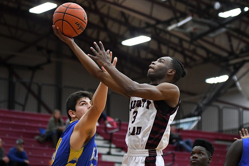 Liberty-Eylau's Anthony Cunningham lays the ball up over North Lamar's Jake Stewart on Tuesday at the Rader Dome in Texarkana, Texas.