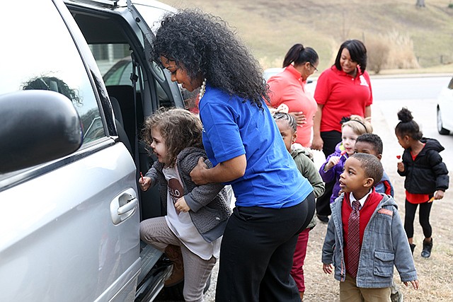 LaKaisha McCaleb helps children into her new van Tuesday at her day care, Joy and Gladness Children's Academy. The van was donated through the program Working Wheels 4 Working Families.