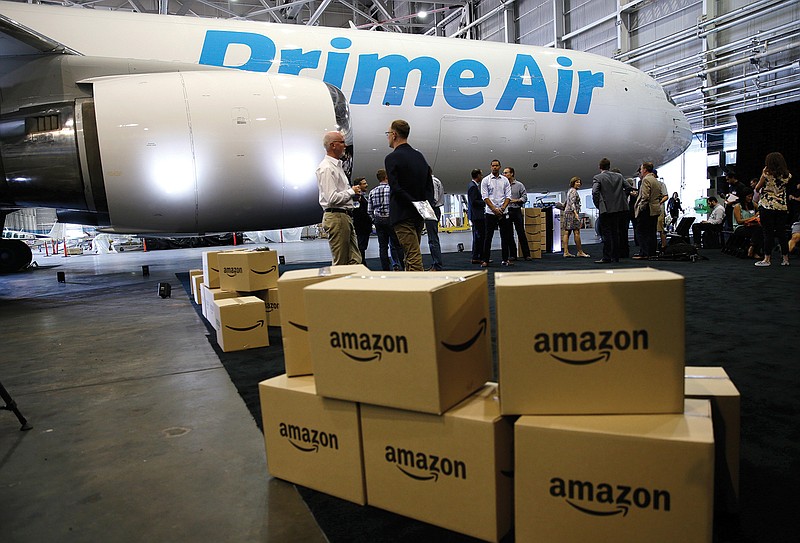 In this Thursday, Aug. 4, 2016, file photo, Amazon.com boxes are shown stacked near a Boeing 767 Amazon "Prime Air" cargo plane on display  in a Boeing hangar in Seattle. Amazon's announcement on Monday, Jan. 30, 2017, of a new air cargo hub in Kentucky is the latest way the e-commerce retailer is dipping its toe, or perhaps whole foot, into building out its shipping and logistics unit. If successful, the move ultimately means lower costs for Amazon but it could eventually pit Amazon against package deliverers like FedEx and UPS. 