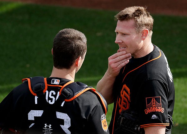 San Francisco Giants relief pitcher Mark Melancon (right) talks to catcher Buster Posey on Tuesday during spring baseball practice in Scottsdale, Ariz.