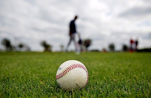 A baseball sits on the field as Boston Red Sox players workout during spring training Monday in Fort Myers, Fla.