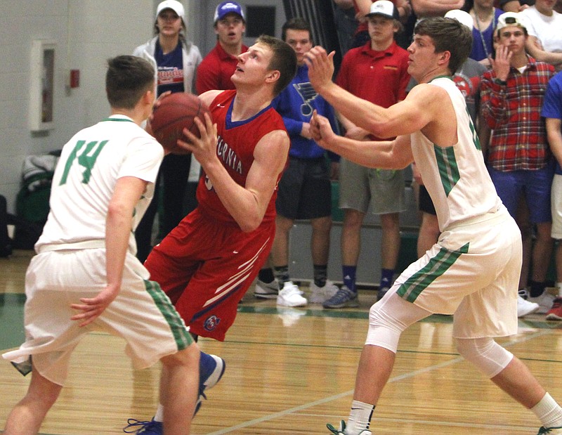 California's Jacob Wolken goes for a lay-up between Blair Oaks players Tim Fick and Jason Rackers.