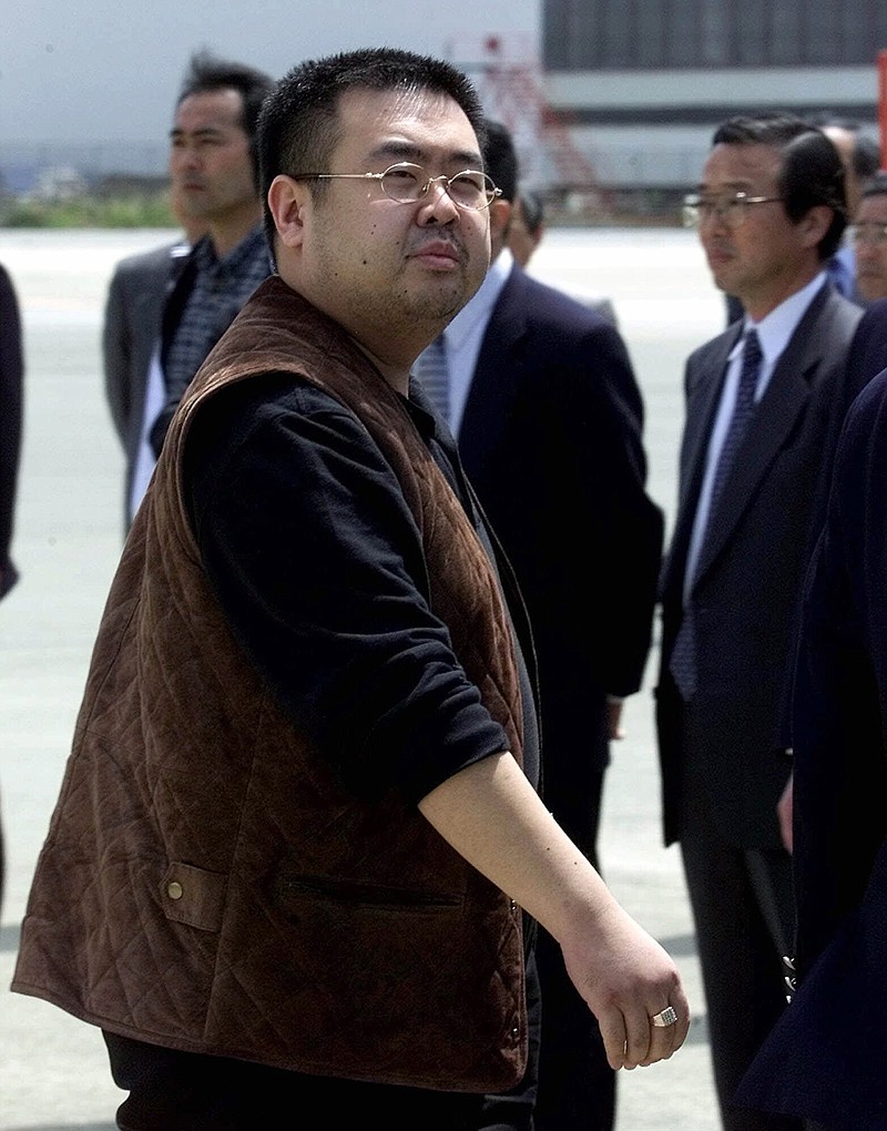 In this May 4, 2001, file photo, a man believed to be Kim Jong Nam, the eldest son of then North Korean leader Kim Jong Il, looks at a battery of photographers as he exits a police van to board a plane to Beijing at Narita international airport in Narita, northeast of Tokyo. Malaysian officials say a North Korean man has died after suddenly becoming ill at Kuala Lumpur's airport. The district police chief said Tuesday feb. 14, 2017 he could not confirm South Korean media reports that the man was Kim Jong Nam, the older brother of North Korean leader Kim Jong Un. 