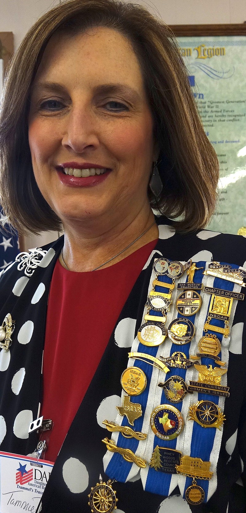 Tammie Duncan of Atlanta wears a shoulder adorned with pins and metals for the National Society of the Daughters of the American Revolution, including ones for her position as regent for the Lone Star DAR Chapter, which meets in Texarkana.