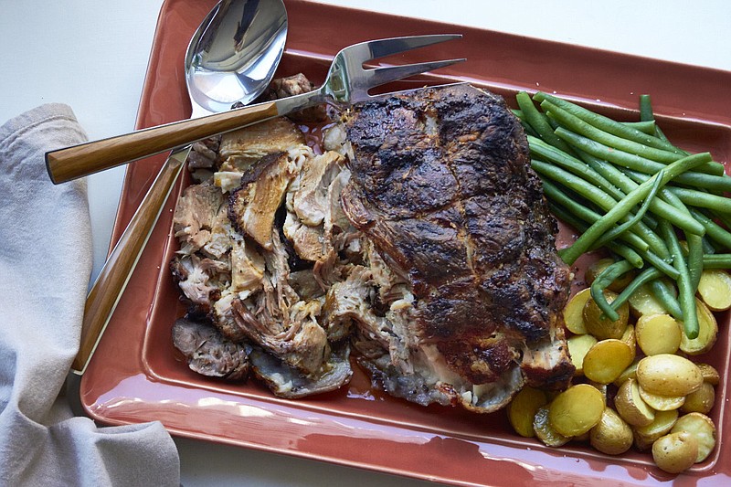 This November 2016 photo shows roasted pork shoulder with rosemary, mustard and garlic in New York. This dish is from a recipe by Katie Workman.
