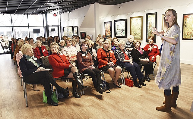Sarah Knee, right, manager of the Jefferson City Museum of Modern Art, points out images from one of three artists featured in the downtown museum. The Tuesday Club held its meeting in the facility to see the art and learn more about it and its creators.