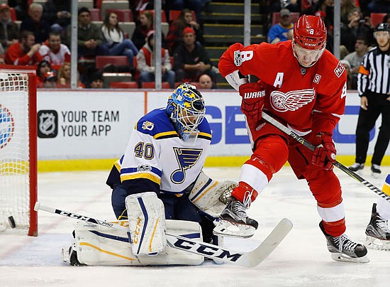 Blues goalie Carter Hutton tries to look past a screen by Justin Abdelkader of the Red Wings during Wednesday night's game in Detroit.