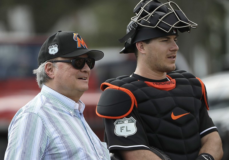 Miami Marlins owner Jeffrey Loria, right, watches with catcher J.T. Realmuto during a spring training baseball workout Tuesday, Feb. 14, 2017, in Jupiter, Fla. 