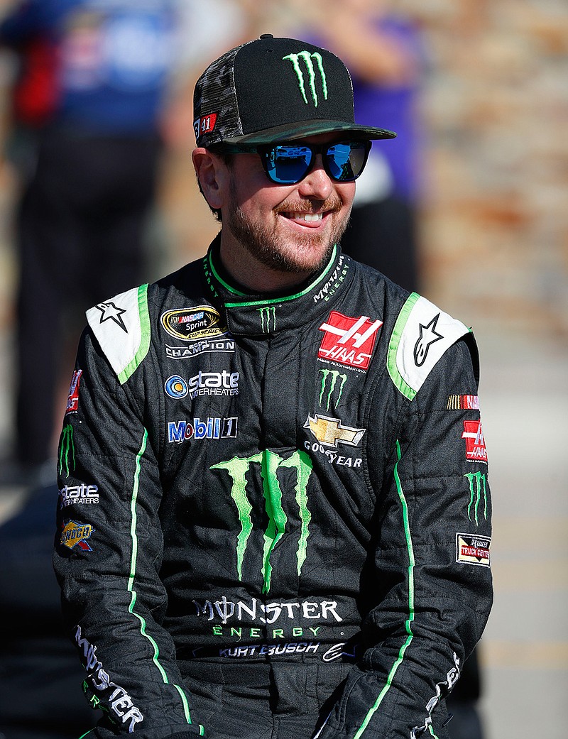In this Aug. 26, 2016, file photo, Kurt Busch, with a Monster Energy logo on the front of his fire suit, smiles before qualifications for a NASCAR Sprint Cup Series auto race at Michigan International Speedway, in Brooklyn, Mich. NASCAR has a new sponsor and a new format this year in its bid to rebound from declining ratings and attendance. The next 11 months will show if Monster Energy and different rules can provide the needed jolt.