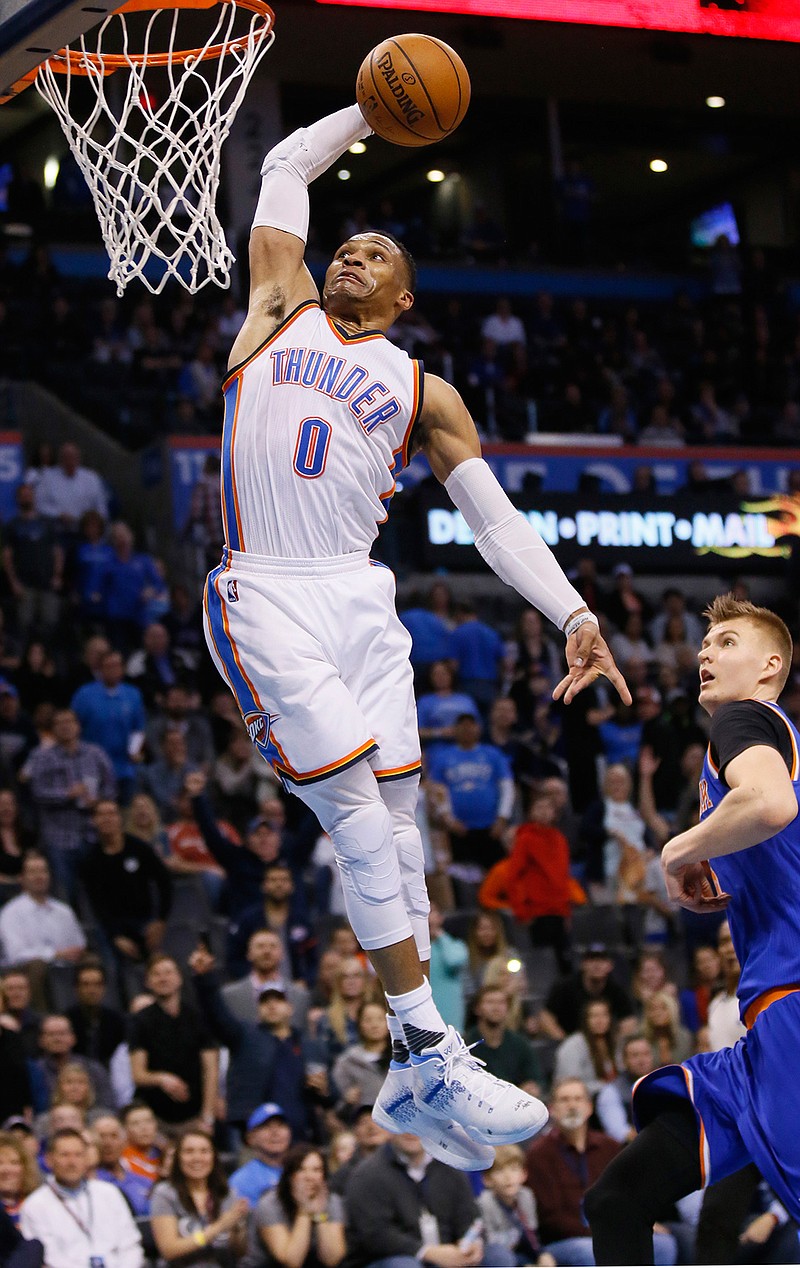 Oklahoma City Thunder guard Russell Westbrook (0) goes up for a dunk in front of New York Knicks forward Kristaps Porzingis (6) during the fourth quarter of an NBA basketball game in Oklahoma City, Wednesday, Feb. 15, 2017. Oklahoma City won 116-105.