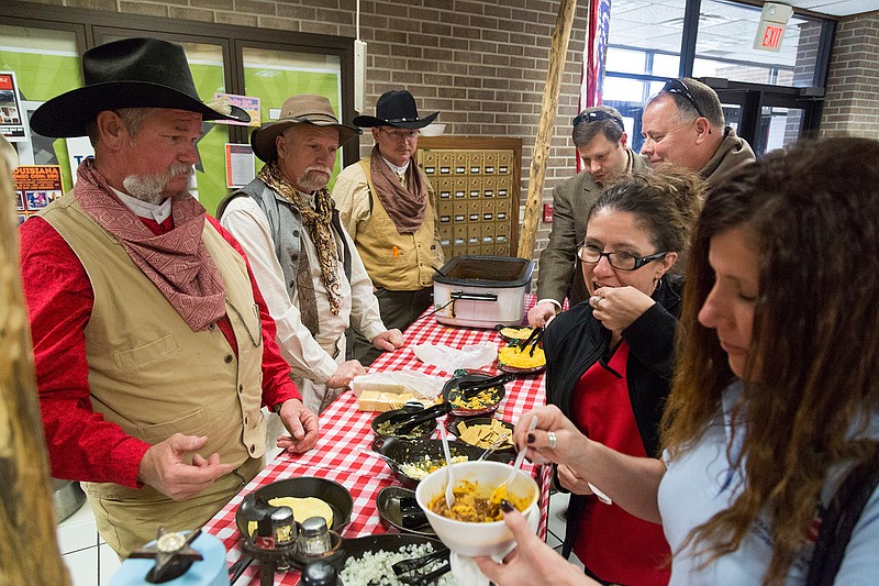 The Wolf Hole Hunting Club gives out chili and toppings Friday at the 18th annual Texarkana Area Veterans Council Chili Cook-Off at Texarkana College. They won first place in the Individual category. 