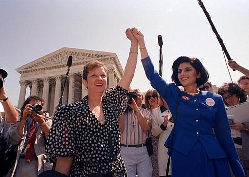  In this April 26, 1989 file photo, Norma McCorvey, Jane Roe in the 1973 court case, left, and her attorney Gloria Allred hold hands as they leave the Supreme Court building in Washington after sitting in while the court listened to arguments in a Missouri abortion case. McCorvey died at an assisted living center in Katy, Texas on Saturday, Feb. 18, 2017, said journalist Joshua Prager, who is working on a book about McCorvey and was with her and her family when she died. He said she died of heart failure.