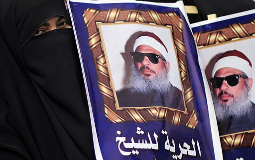  In this Feb. 26, 2012 file photo, Egyptian protesters hold posters showing Sheikh Omar Abdel-Rahman, who is imprisoned in the US, and call for his release outside a court in Cairo, Egypt. Abdel-Rahman died , Saturday, Feb. 18, 2017 after suffering from diabetes and coronary artery disease, said Kenneth McKoy at the Federal Correction Complex in Butner, N. C. 