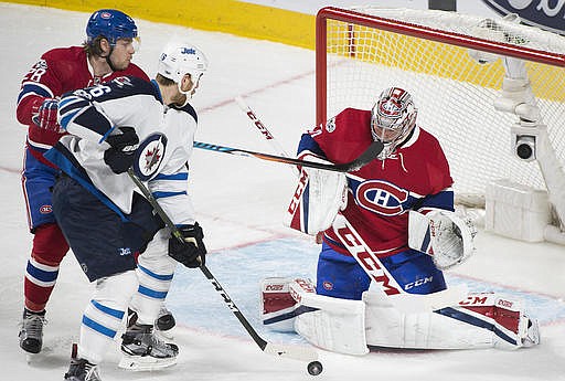 Montreal Canadiens goaltender Carey Price makes a save against Winnipeg Jets' Shawn Matthias (16) as Canadiens' Nathan Beaulieu (28) defends during the first period of an NHL hockey game in Montreal, Saturday, Feb. 18, 2017.