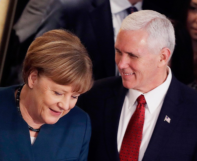 German Chancellor Angela Merkel, left, and United States Vice President Mike Pence arrive at the Munich Security Conference in Munich, Germany, Saturday, Feb. 18, 2017. The annual weekend gathering is known for providing an open and informal platform to meet in close quarters. 